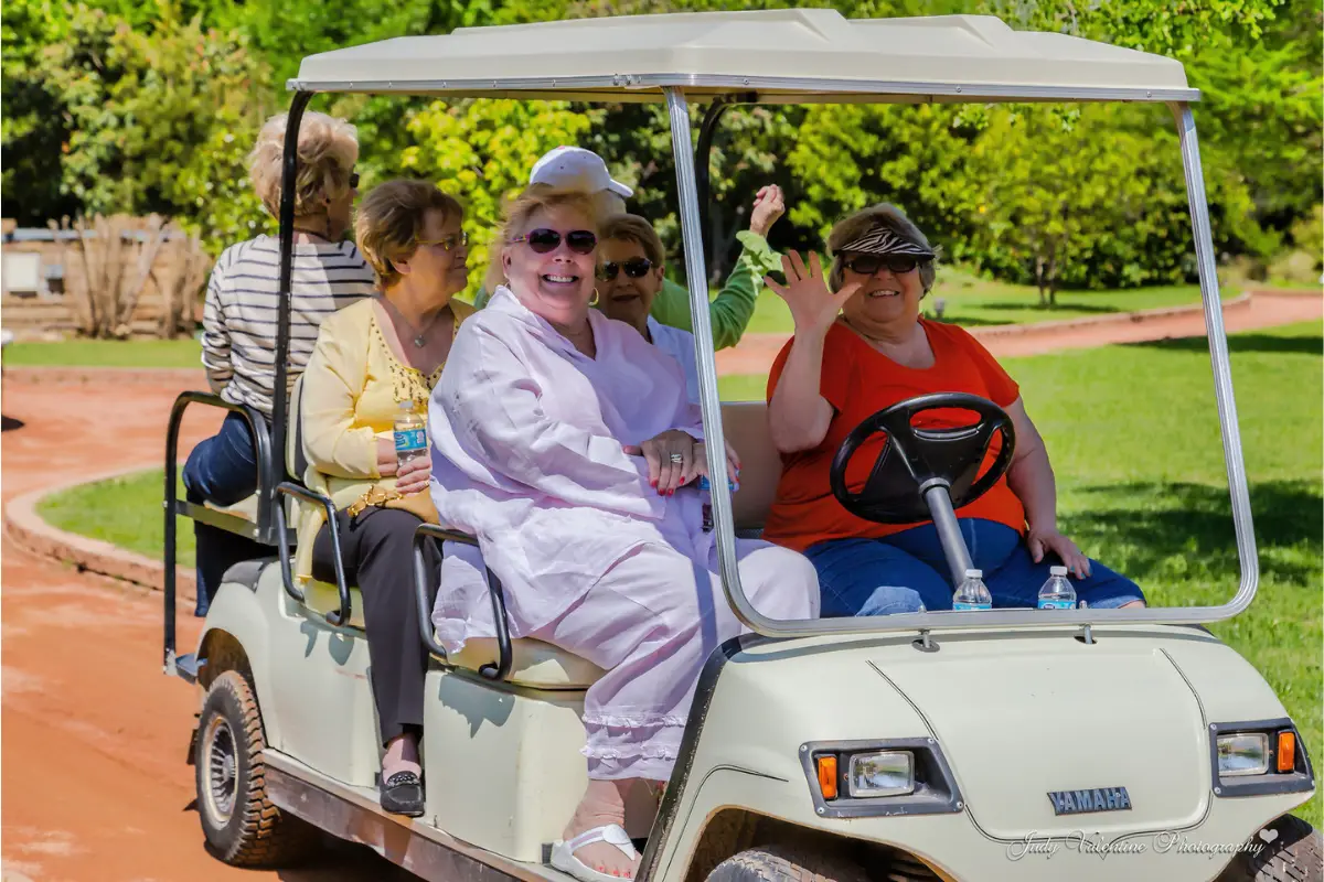Golf cart with docent leading a group of women on a tour of Clark Gardens