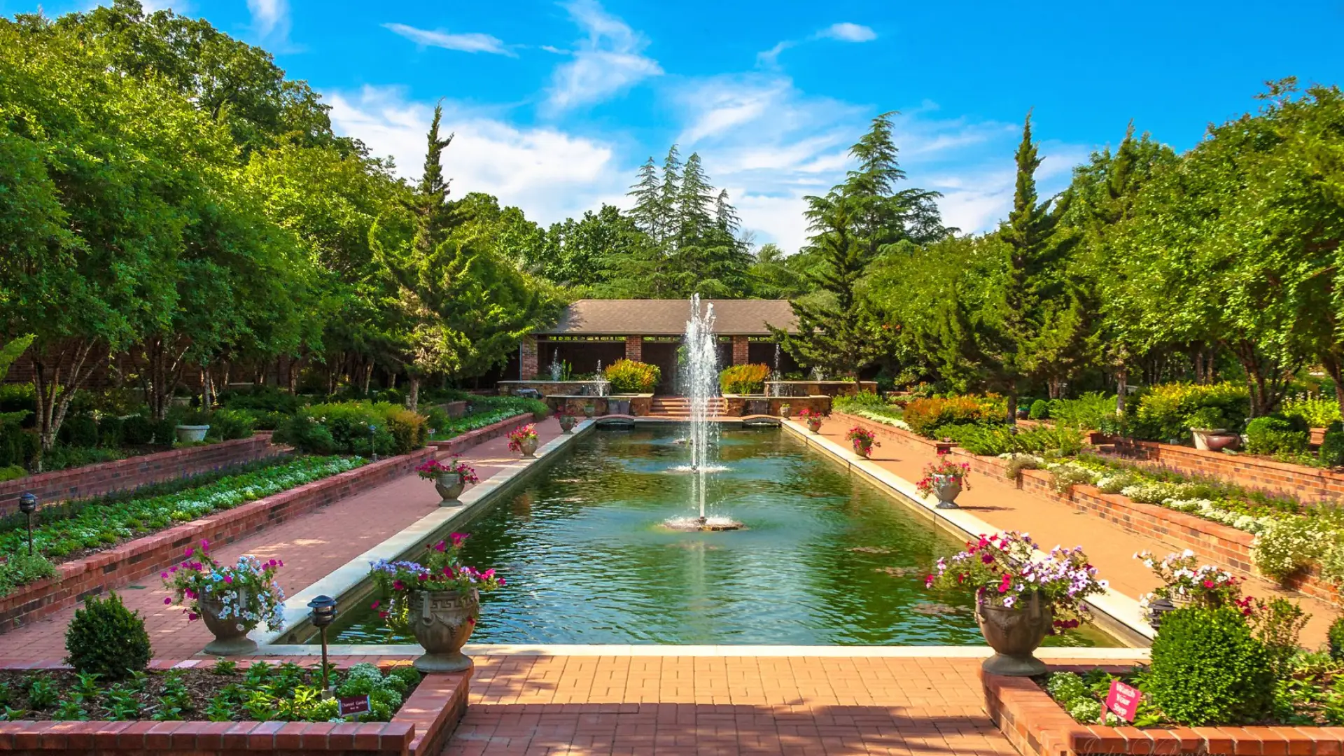 Channel Gardens at Clark Gardens Botanical Park with reflecting pool, fountains, and colorful seasonal flowers.