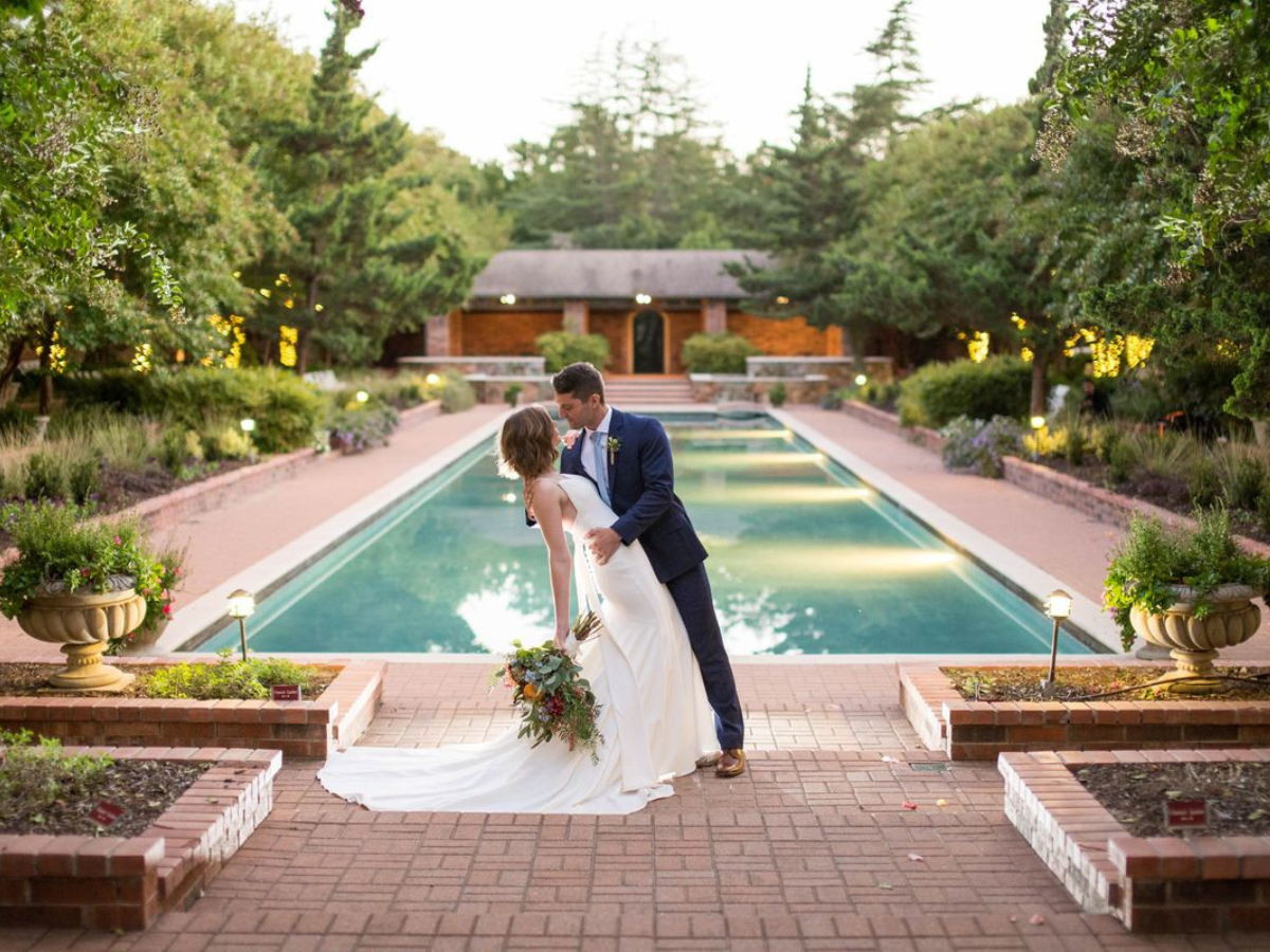 wedding couple in front of the Channel Gardens fountains at Clark Gardens Botanical Park